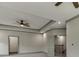 Spacious bedroom featuring a tray ceiling with a ceiling fan and neutral wall colors at 4208 Sierra Creek Ct, Hoschton, GA 30548
