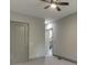 Hallway features neutral paint, carpeted floors, and a ceiling fan with doors and stair access at 4208 Sierra Creek Ct, Hoschton, GA 30548