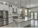 Updated kitchen with island, stainless steel appliances, gray countertops, and pendant lights at 4208 Sierra Creek Ct, Hoschton, GA 30548