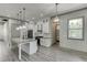 Bright kitchen features an island with a sink, white cabinets, stainless steel appliances, and wood floors at 4208 Sierra Creek Ct, Hoschton, GA 30548