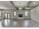 Spacious living room with fireplace, wood floors, coffered ceiling, and modern lighting at 4208 Sierra Creek Ct, Hoschton, GA 30548