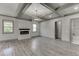 Open-concept living room with fireplace, hardwood floors, and access to a bathroom at 4208 Sierra Creek Ct, Hoschton, GA 30548