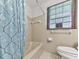Bathroom featuring a bathtub with a shower curtain and blinds on the window at 10381 E Cherokee Dr, Canton, GA 30115