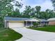 Single-story brick house with a long driveway and an attached garage surrounded by lush trees and greenery at 10381 E Cherokee Dr, Canton, GA 30115