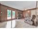 Cozy living room features a brick fireplace, wood-paneled walls, and sliding glass doors to the backyard at 10381 E Cherokee Dr, Canton, GA 30115