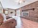 Cozy living room with brick fireplace, ceiling fan, and wood paneling at 10381 E Cherokee Dr, Canton, GA 30115