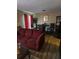 Cozy living room with hardwood floors, dining table, and a comfortable burgundy sofa at 22 Fairview Dr, Jonesboro, GA 30238