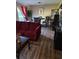 Open living room with a burgundy sofa, hardwood floors, and a dining area at 22 Fairview Dr, Jonesboro, GA 30238