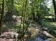 Beautiful view of a backyard creek, trees, and a gazebo, offering a serene outdoor space at 235 Pirkle Ct, Cumming, GA 30040