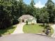 Inviting home with manicured lawn, mature trees, and a long driveway at 235 Pirkle Ct, Cumming, GA 30040
