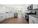 Open kitchen with stainless steel appliances, granite countertops, island, and modern lighting at 2975 Jefferson St, Austell, GA 30106