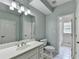 Bright bathroom features a large mirror, white vanity, and tile flooring, offering a clean and modern aesthetic at 6010 Somerset Ct, Suwanee, GA 30024
