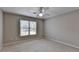 Neutral bedroom with a ceiling fan, window, and plush carpet flooring at 6010 Somerset Ct, Suwanee, GA 30024