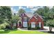 Beautiful two-story brick home with manicured lawn and mature trees at 6010 Somerset Ct, Suwanee, GA 30024
