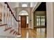 Grand foyer with hardwood floors, staircase, and leaded glass doorway at 6010 Somerset Ct, Suwanee, GA 30024