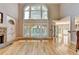 Spacious living room with hardwood floors, stone fireplace, and large windows at 6010 Somerset Ct, Suwanee, GA 30024