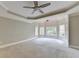 Spacious main bedroom featuring a ceiling fan, tray ceiling, and multiple windows for abundant natural light at 6010 Somerset Ct, Suwanee, GA 30024
