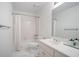 This all-white bathroom features a shower-tub combo, a single sink and modern fixtures at 12160 Oak Hollow Way, Alpharetta, GA 30005