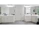 Bathroom includes double sink vanity with large mirrors, carpeted floor, and doorway to additional rooms at 12160 Oak Hollow Way, Alpharetta, GA 30005