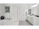 Elegant bathroom featuring tub, tiled floors, neutral gray carpet, white cabinets, double doors, and unique decor at 12160 Oak Hollow Way, Alpharetta, GA 30005