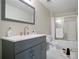The renovated bathroom features a gray vanity, modern fixtures, and a tile shower-tub combo at 12160 Oak Hollow Way, Alpharetta, GA 30005