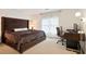 This bedroom features a luxurious bed, desk, floor lamp, and window with sheer curtains at 12160 Oak Hollow Way, Alpharetta, GA 30005