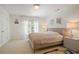 A stylish bedroom features soft, natural lighting, neutral colors and a large window at 12160 Oak Hollow Way, Alpharetta, GA 30005
