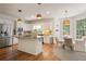 Open kitchen with granite island, stainless appliances, and adjacent dining area at 12160 Oak Hollow Way, Alpharetta, GA 30005