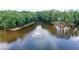 Scenic aerial view of a pond with a fountain, surrounded by lush greenery and mature trees at 12160 Oak Hollow Way, Alpharetta, GA 30005