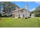 A view of the back of the home showing the chimney, back patio, and an ample green backyard at 1900 Green Oak Cir, Lawrenceville, GA 30043