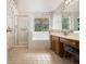 Bright bathroom features a tub, separate shower, double vanity, decorative wallpaper, and tile floors at 1900 Green Oak Cir, Lawrenceville, GA 30043