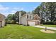 View of the home's side yard with ample green space, mature trees, and brick detailing at 1900 Green Oak Cir, Lawrenceville, GA 30043