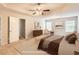 A staged main bedroom with tray ceiling, ceiling fan, and multiple windows at 219 Sleepy Way, Canton, GA 30114