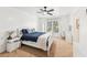 Bright bedroom boasts a ceiling fan, plush carpet, a white bed with blue bedding, and natural light from the window at 2720 Stillwater Lake Ln, Marietta, GA 30066