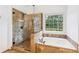 Spa-like main bathroom featuring a glass-enclosed shower and separate soaking tub with tile surround at 2720 Stillwater Lake Ln, Marietta, GA 30066