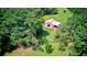 Aerial view of a charming red barn surrounded by green pastures and mature trees at 4393 Cannon Rd, Loganville, GA 30052
