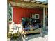 Outdoor view of a tractor and mower stored under a lean-to attached to a red barn at 4393 Cannon Rd, Loganville, GA 30052