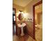 Bathroom with tiled floors, a pedestal sink, and a shower over tub enclosure in the adjoining room at 4393 Cannon Rd, Loganville, GA 30052