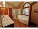 Bathroom featuring dual sinks, a jacuzzi tub, and a glass shower at 4393 Cannon Rd, Loganville, GA 30052