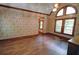 This bedroom boasts unique wallpaper, wood floors, and large windows for natural light at 4393 Cannon Rd, Loganville, GA 30052