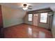 An empty bedroom features hardwood flooring, a ceiling fan, and natural light coming through the windows at 4393 Cannon Rd, Loganville, GA 30052