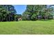 Spacious grassy land with trees and a red barn in the background providing a serene environment at 4393 Cannon Rd, Loganville, GA 30052