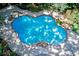 Aerial view of uniquely shaped pool surrounded by a brick border and concrete patio at 4393 Cannon Rd, Loganville, GA 30052