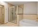 Well-lit bathroom featuring a glass enclosed shower, soaking tub, and tiled walls at 855 Peachtree Ne St # 3304, Atlanta, GA 30308