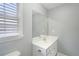 Powder room features a white vanity, large mirror, and a window with white blinds at 1010 Capella Creek Way, Grayson, GA 30017