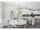Bright eat-in kitchen features a modern chandelier, white cabinetry, and a breakfast bar at 1010 Capella Creek Way, Grayson, GA 30017