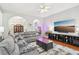 Cozy living room with plush seating, hardwood flooring, tv, and a view of the dining room at 1010 Capella Creek Way, Grayson, GA 30017