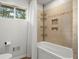 Clean bathroom with a tub and shower featuring tiled walls and built-in storage at 2703 Carolyn Se Dr, Smyrna, GA 30080