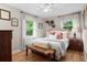 Cozy bedroom with natural light, wood floors, and a decorative bench at the foot of the bed at 2703 Carolyn Se Dr, Smyrna, GA 30080