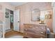 Bedroom with pink walls, decorative wallpaper, wood floors, and classic dresser at 2703 Carolyn Se Dr, Smyrna, GA 30080